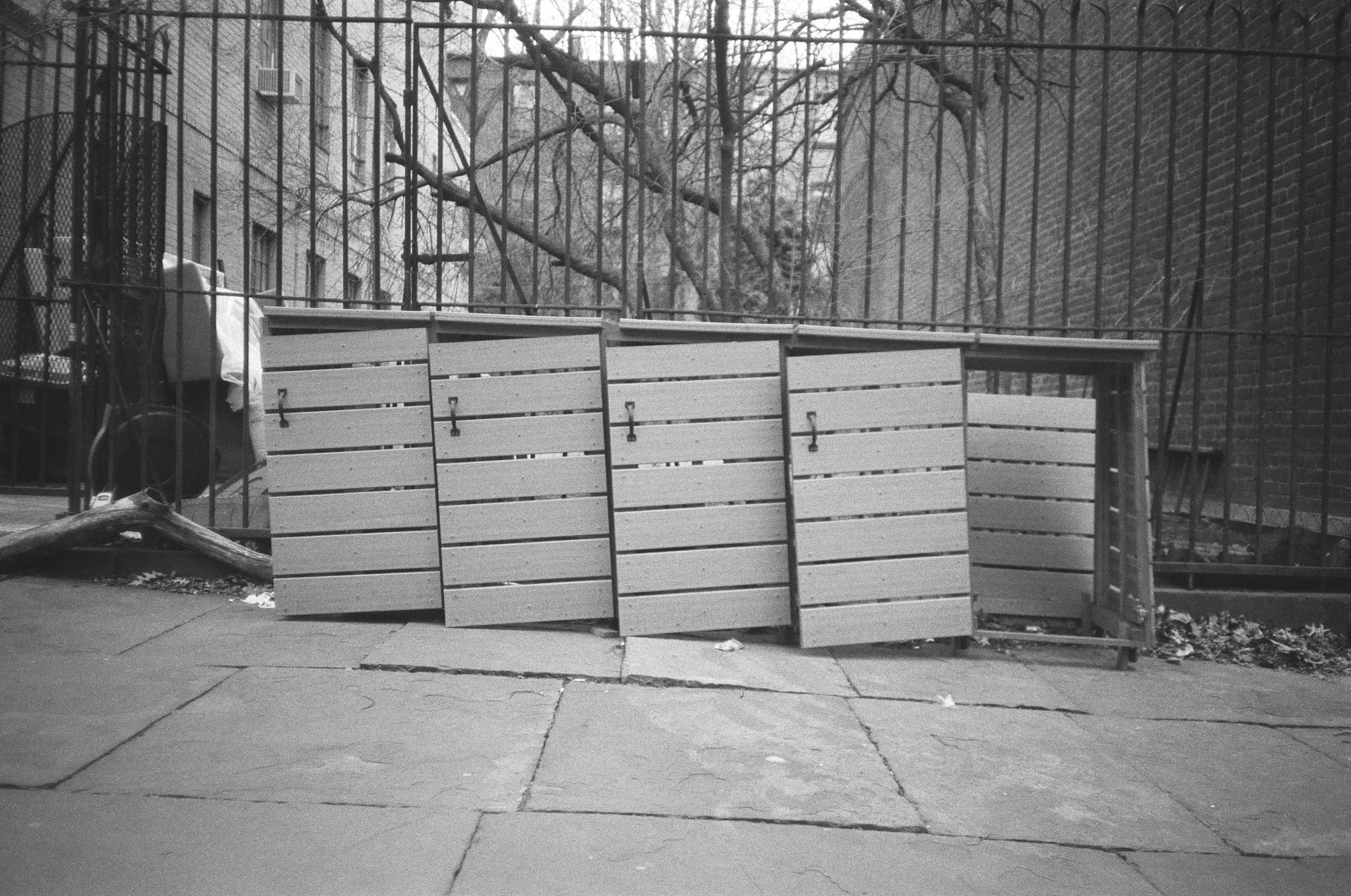 A row of trash can holders that has partially collapsed.