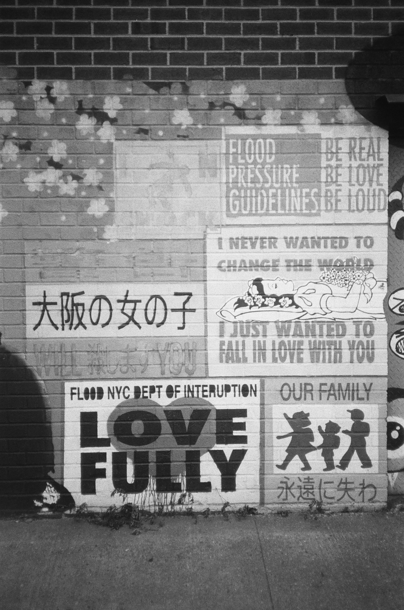 A graffitied wall with kanji and messages from the Flood NYC Department of Interruption