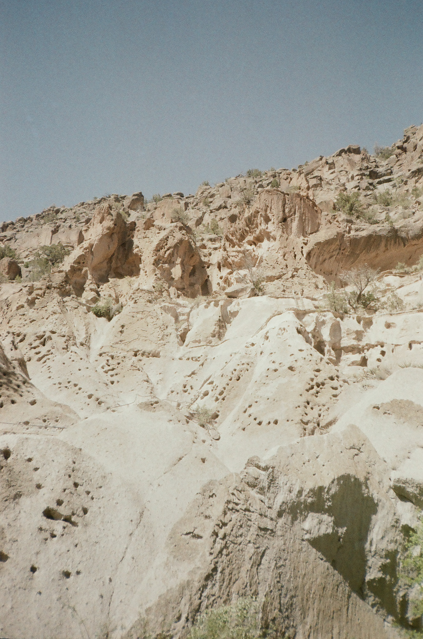Rockwall in Bandolier, New Mexico. The wall is dotted with holes original cut to hold structures all the way up the side of the cliff face.
