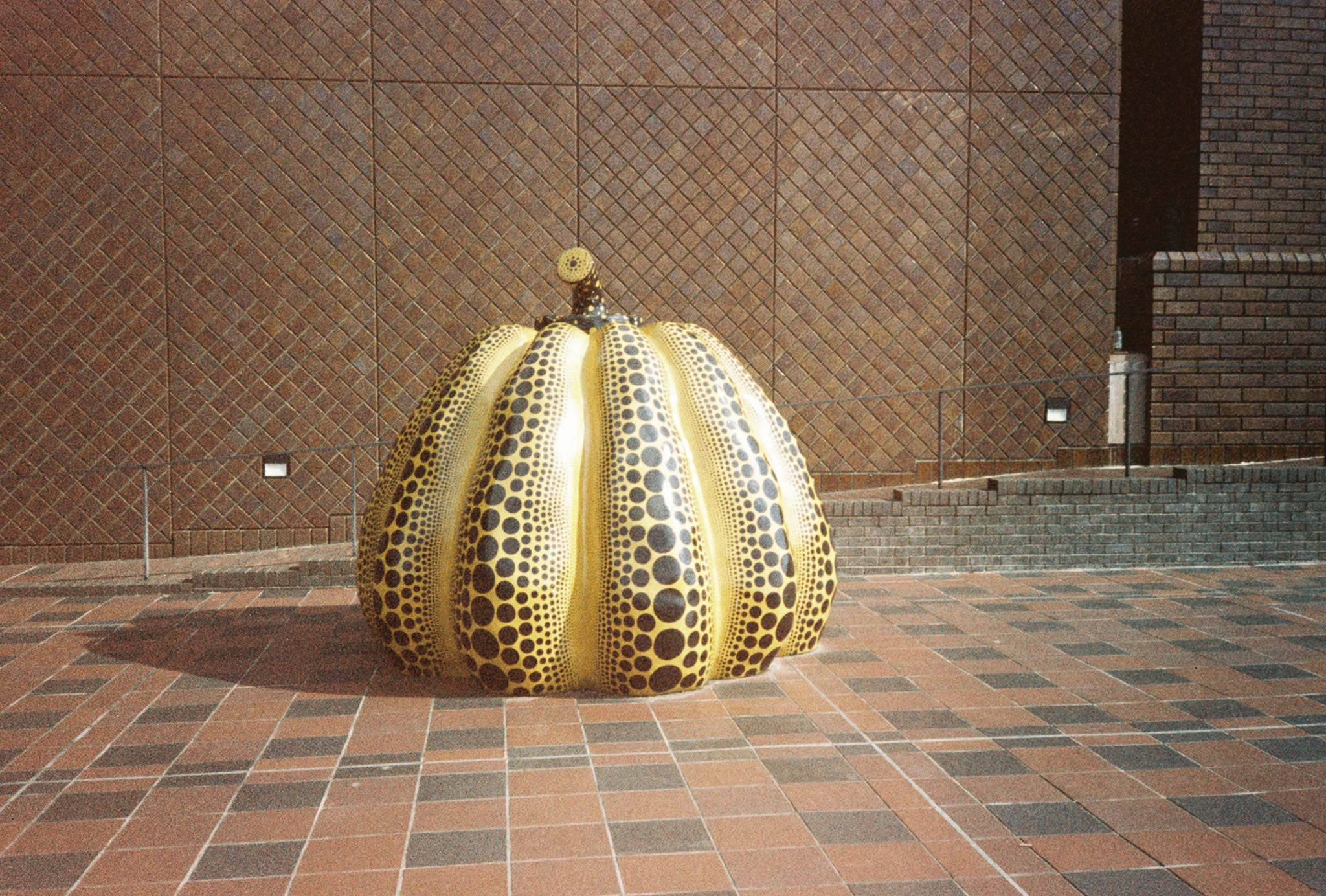 A Yayoi Pumpkin. The pumpkin is about 5 feet tall, yellow with black dots.