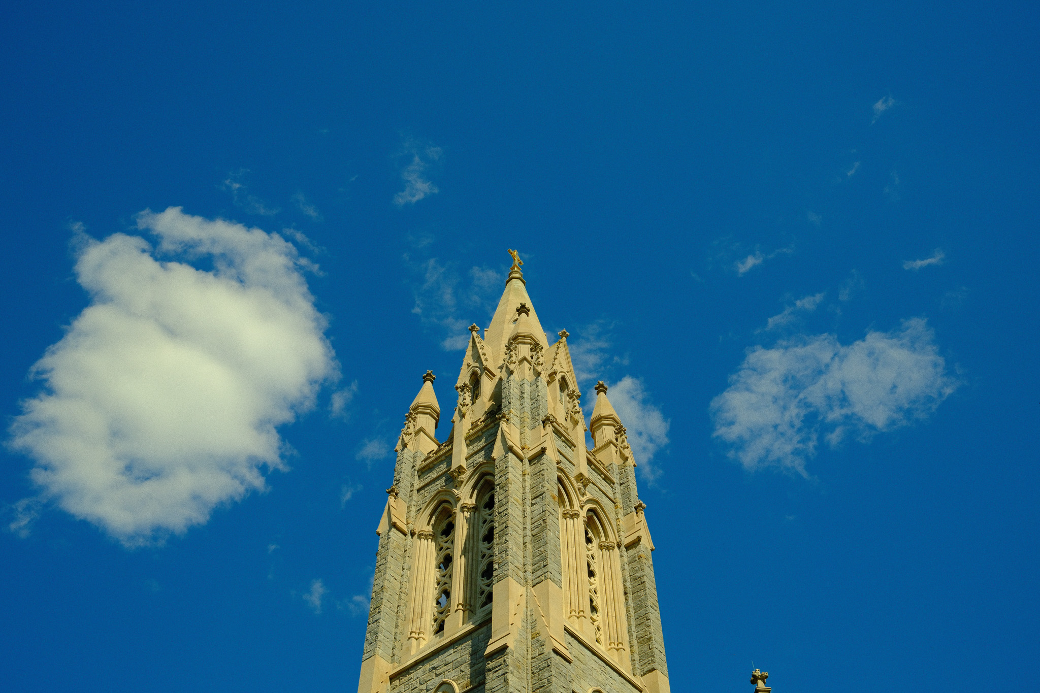 The steeple of a church against a blue sky.