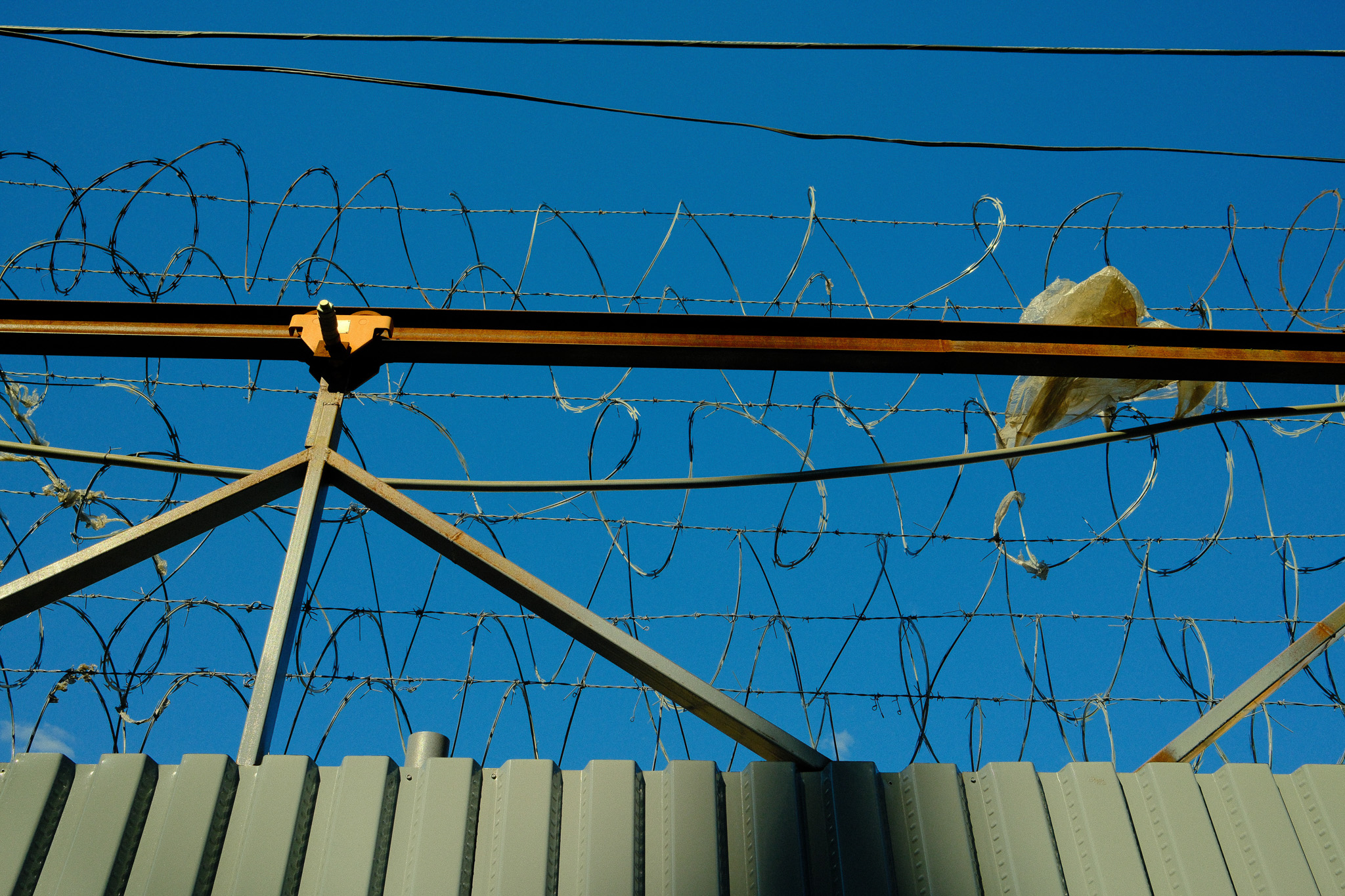 Barbed wire at the top of a fence.