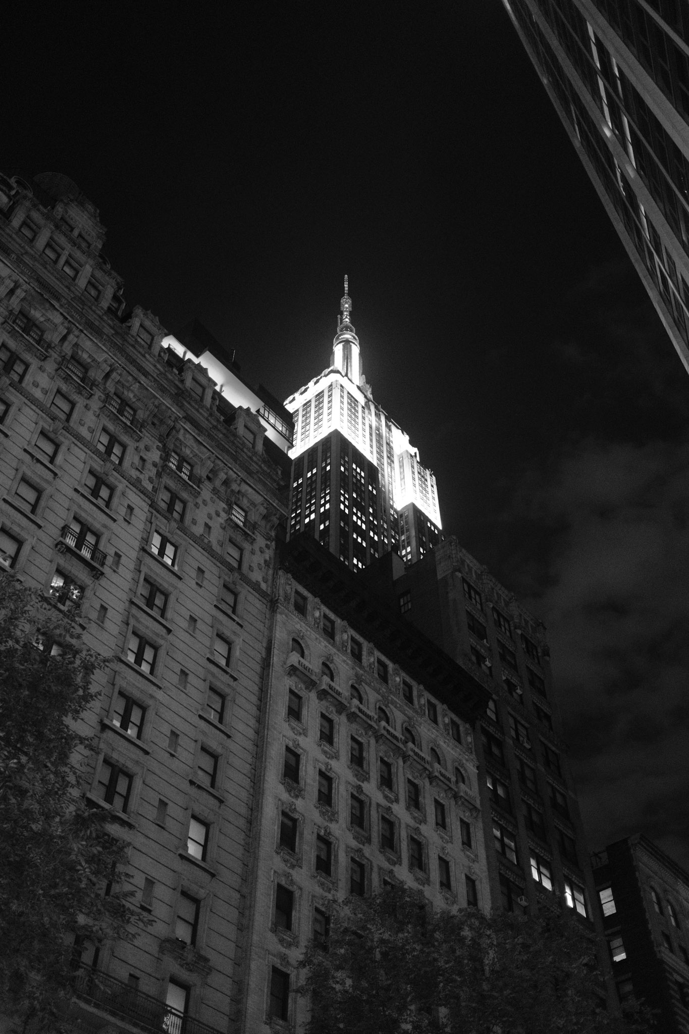 Night shot of the empire state building lit up in BW from below