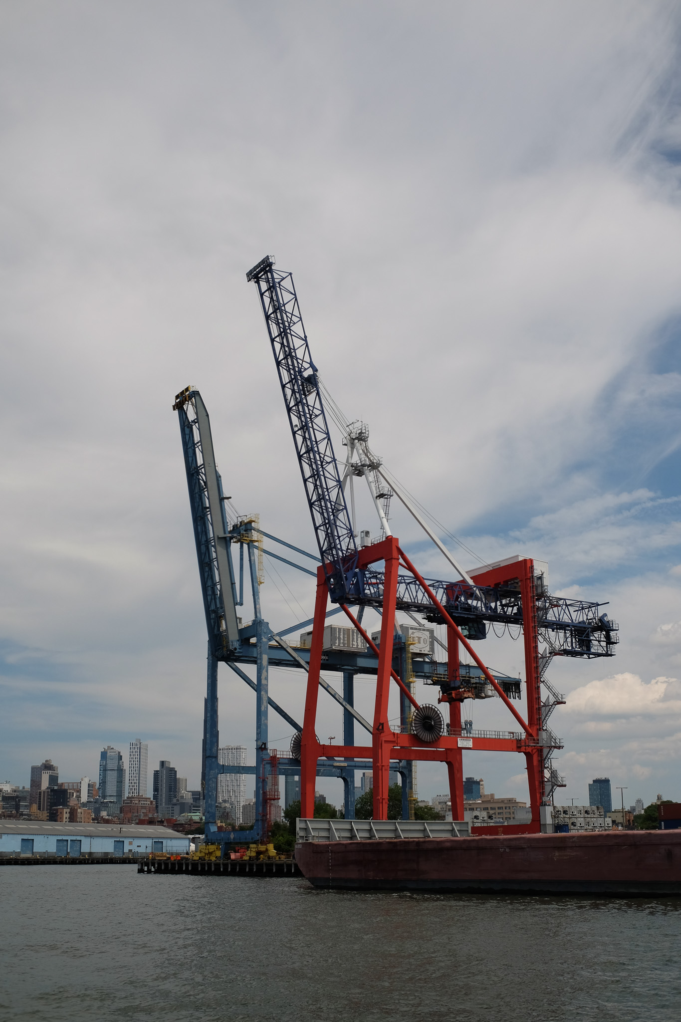 2 cargo cranes sitting on a dock.